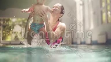 白人年轻母亲和可爱的可爱婴儿在游泳池游泳。 微笑的妈妈和小孩，男孩玩得开心